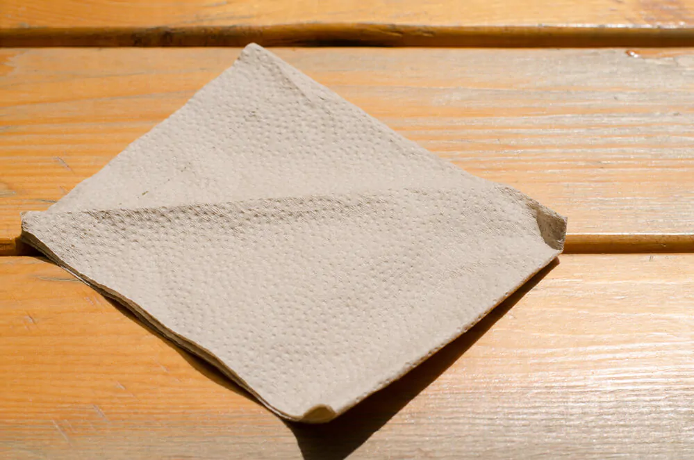 A brown paper napkin on a wooden surface
