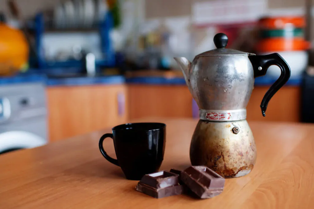 a dirty coffee maker, a mug, a chocolate