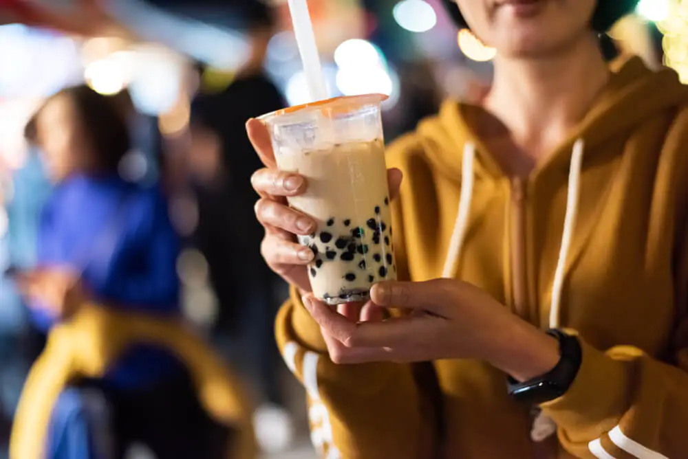 a woman holding a bubble tea with her both hands