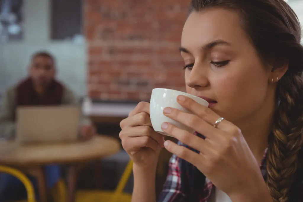 a woman sipping a cup of coffee