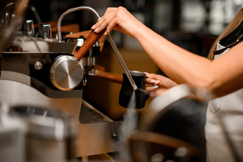 Why Do You Purge The Steam Wand - Baristas hand that turns on the coffee machine to release steam