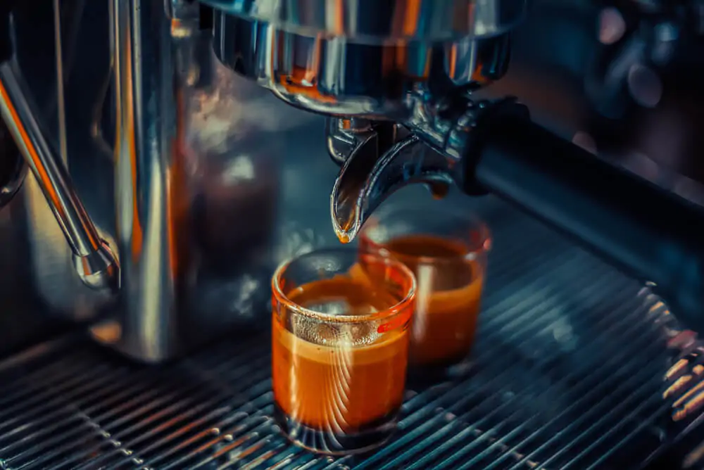 two cups of freshly brewed espresso shot using an espresso machine