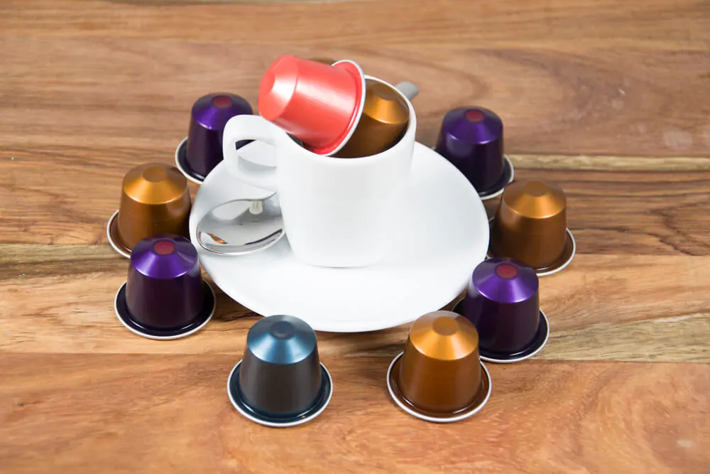 coffee capsules with a cup and spoon on the top of a plate