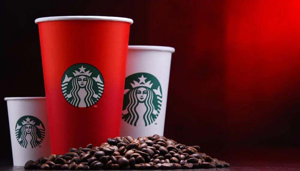 three cups of Starbucks with different sizes and coffee beans 
