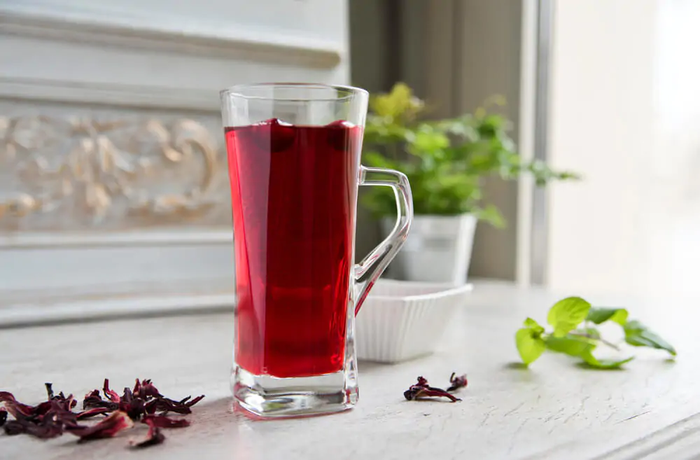 Red hibiscus tea in a transparent glass - What is hibiscus tea good for