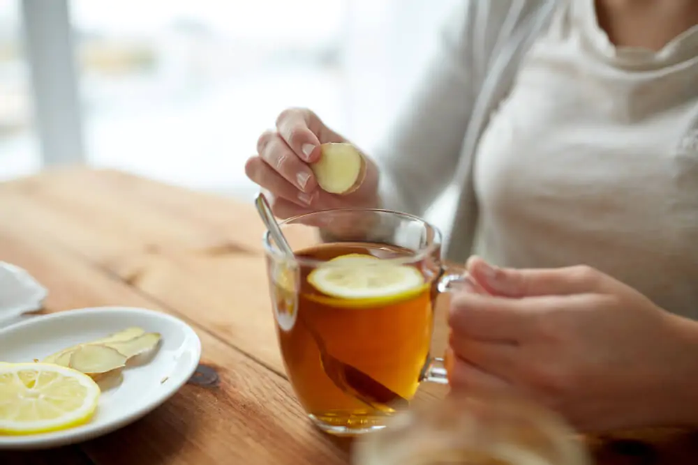 woman putting the peeled ginger  in her tea