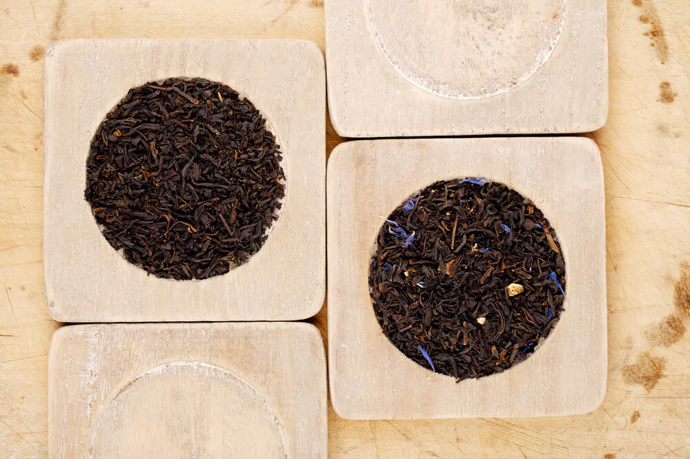 Earl Grey and Lady Grey black loose tea leaves on wood