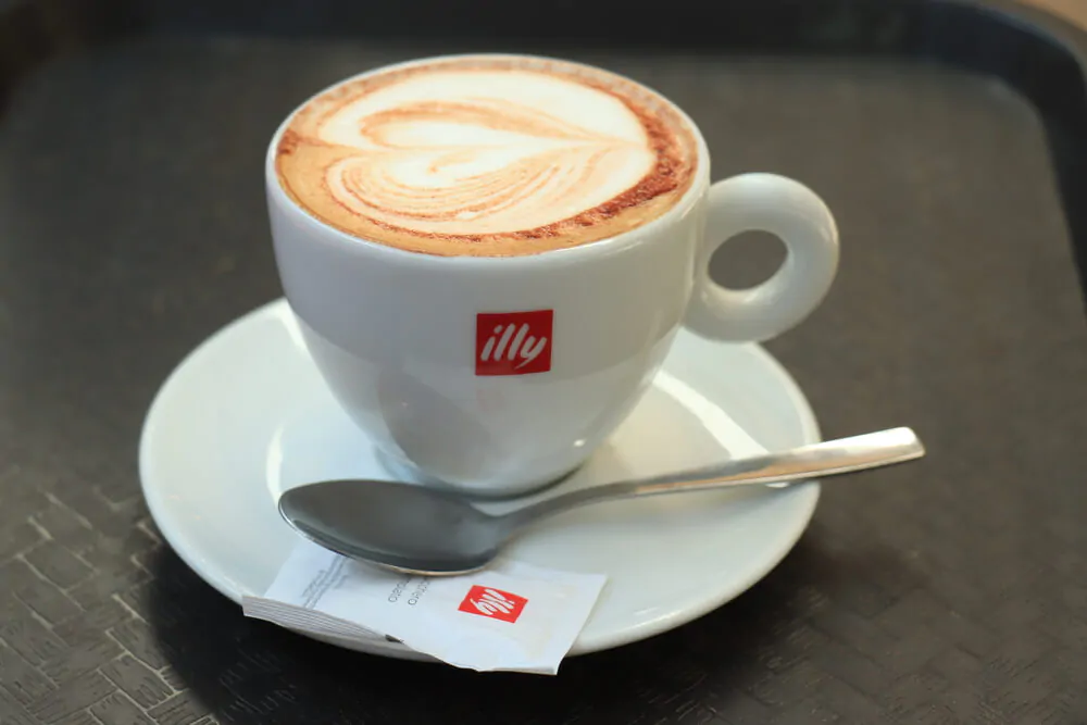 Illy Cappuccino in a branded coffee cup with Illy sugar