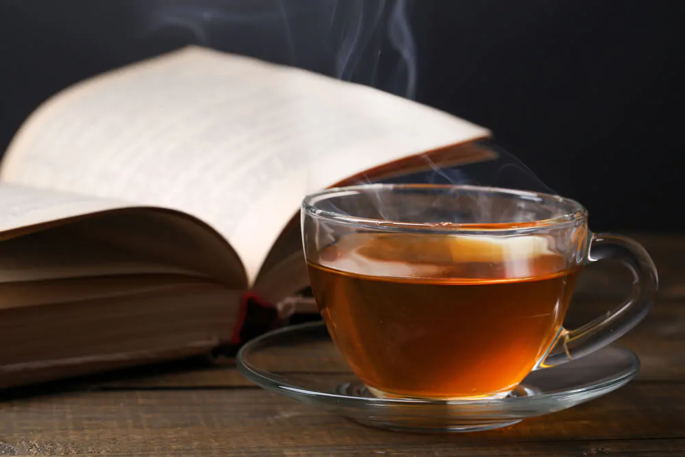 Cup of hot tea with book on table - What is Sassafras tea