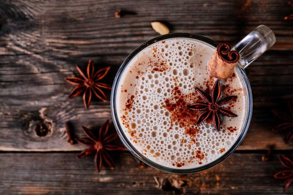 Homemade Chai Tea Latte with anise and cinnamon stick in glass mug - What is Vanilla Chai Latte