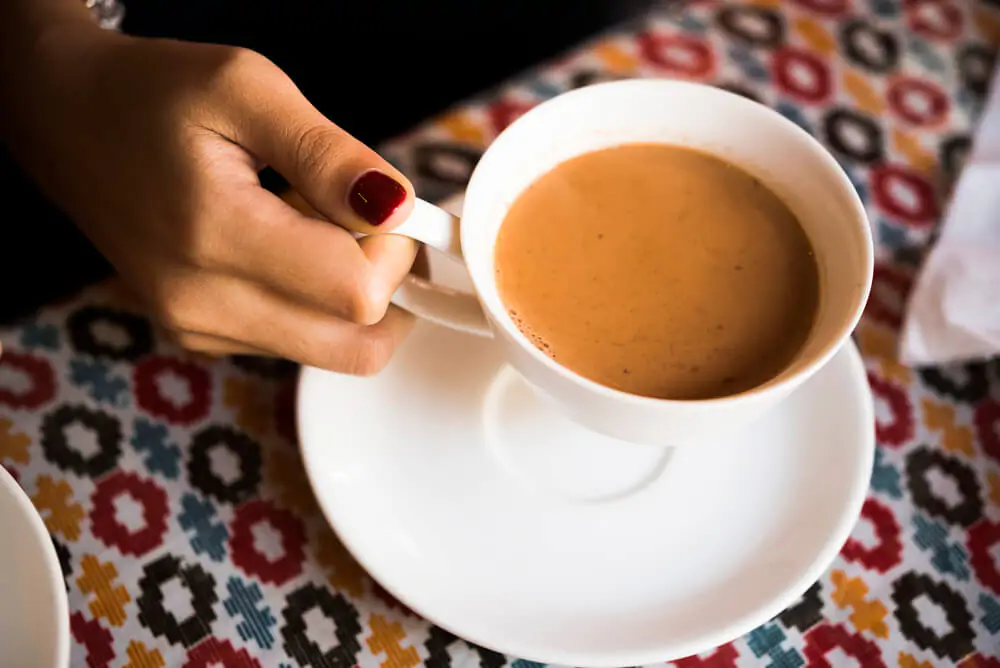 a woman holding a cup of chai tea