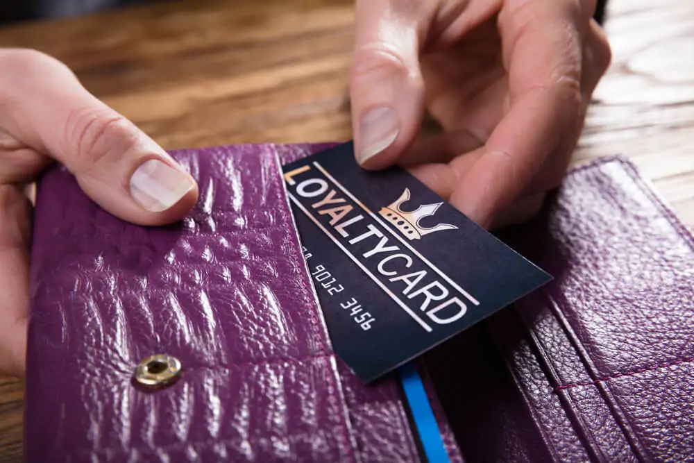 Close-up Of A Businessperson's Hand Removing Loyalty Card From Purse
