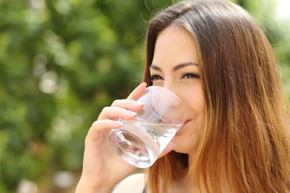 a woman sipping water while smiling