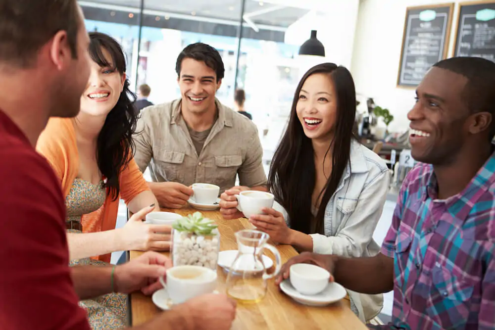 group of friends talking happily while in a coffee shop