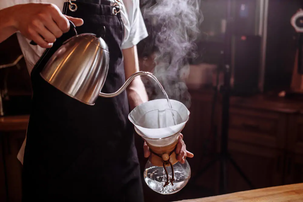 what is Chemex coffee - barista pouring a hot water to a Chemex