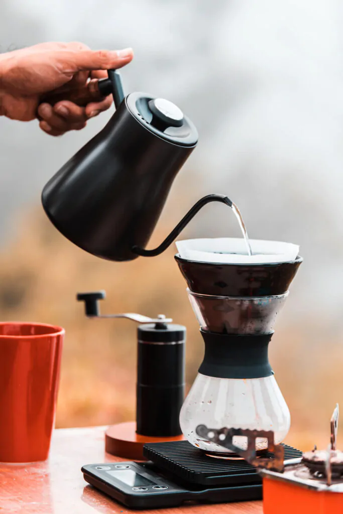 Barista brewing coffee using pour over coffee maker