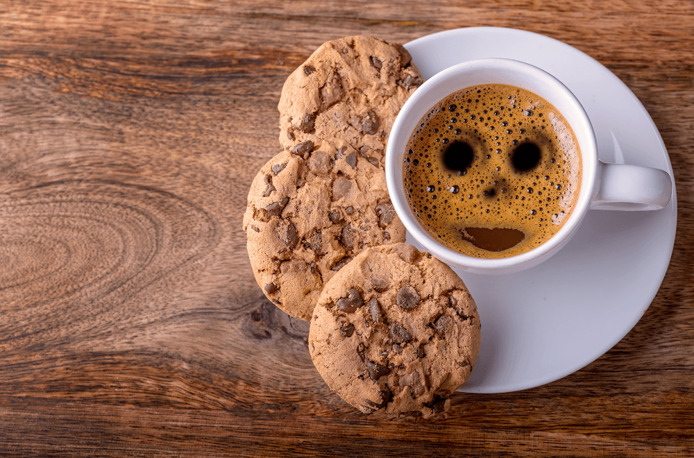 Three cookies and a coffee with a bubbles forming a smile