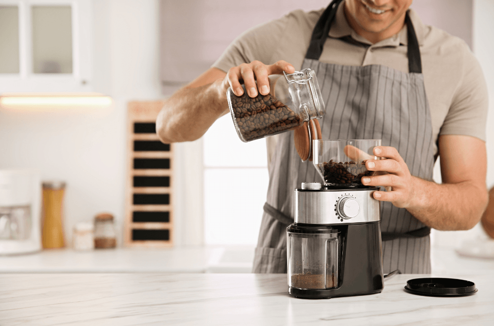 pouring coffee beans in electric grinder