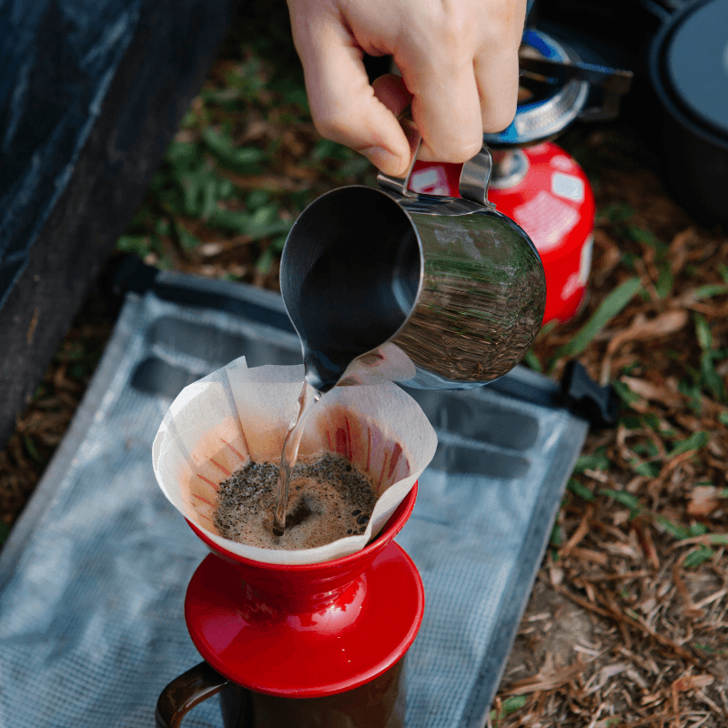 using a pour-over coffee maker in campsite