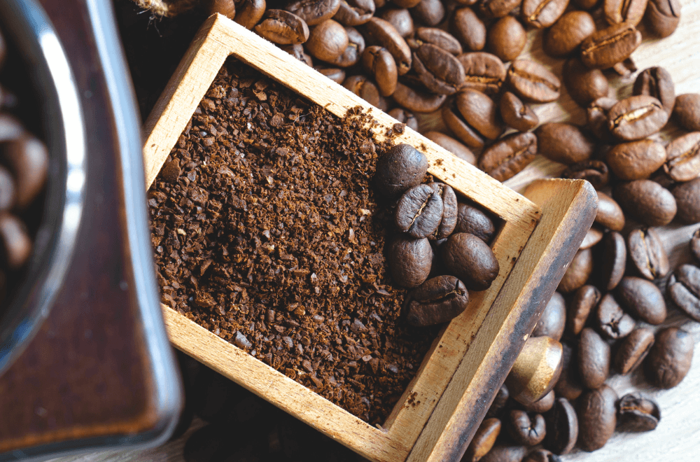 Coffee grinder with coffee beans on the wooden table