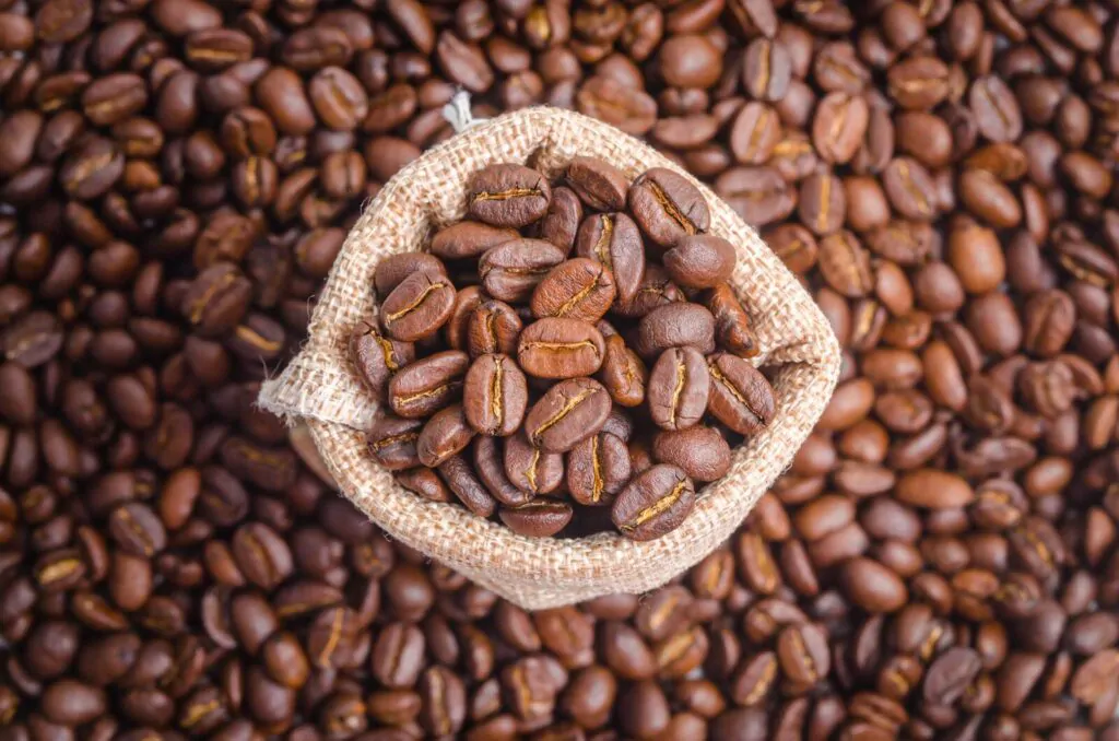 Coffee beans in sack bag on coffee beans background
