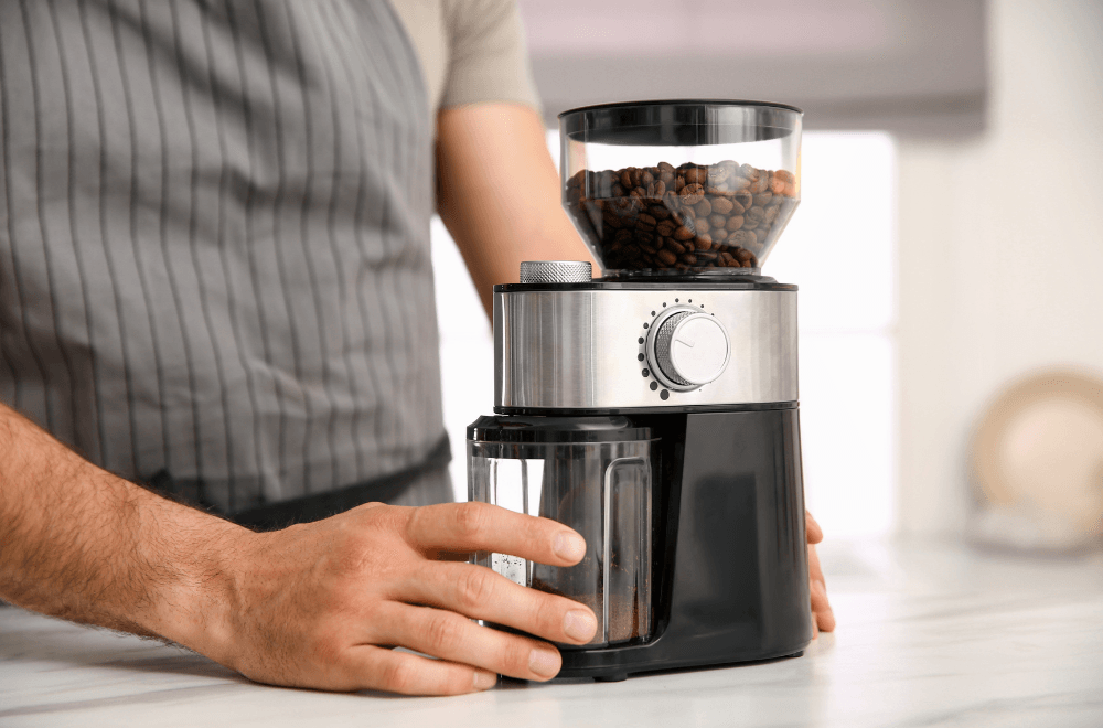 A man holding his electric coffee grinder