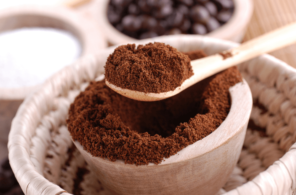A spoonful of coffee grounds in the white basket