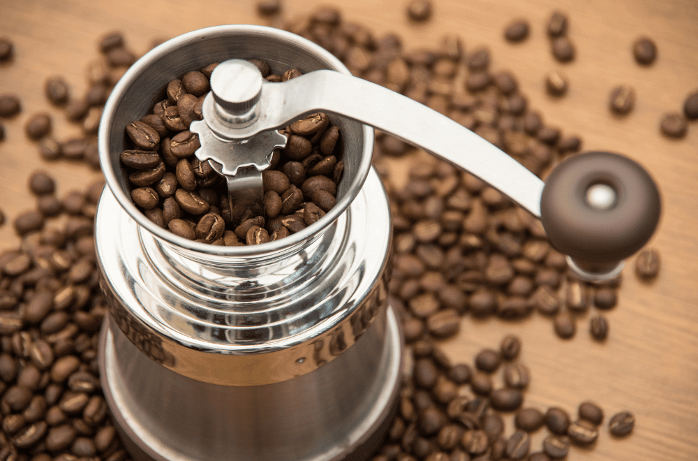 Steel coffee grinder full of coffee beans