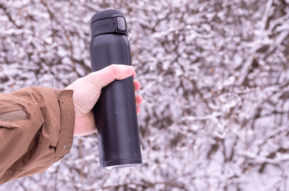 Vacuum insulated mugs in the left hand. Drink coffee in the winter.