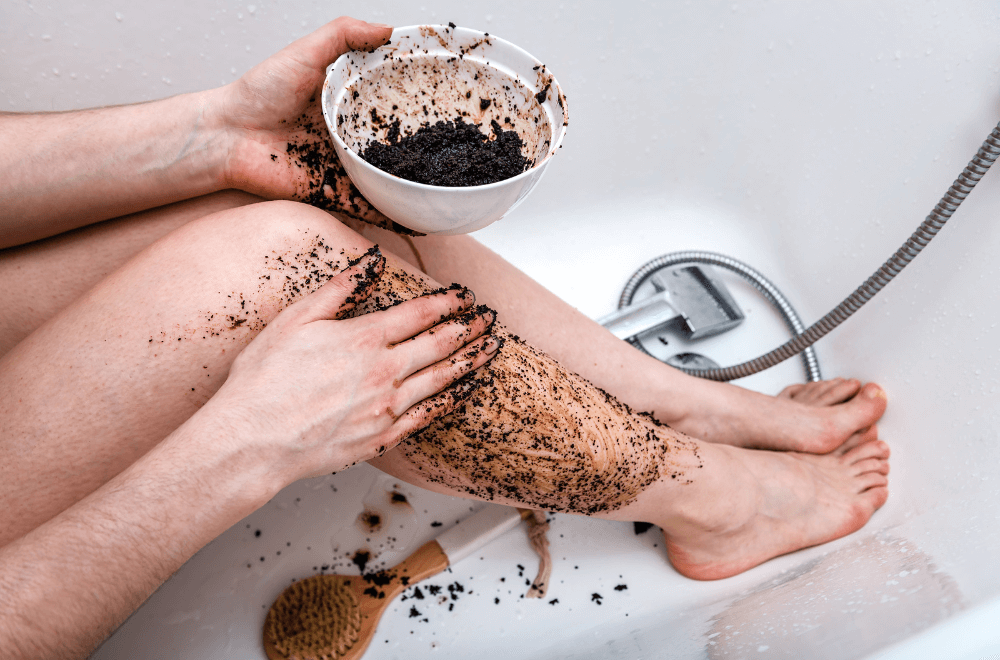 Young charming sexy girl makes coffee foot scrub in the bathroom