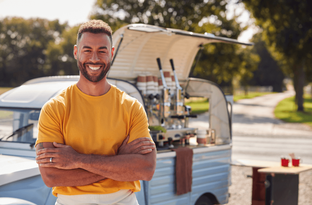 Portrait Of Man Running Independent Mobile Coffee Shop Standing Outdoors Next To Van