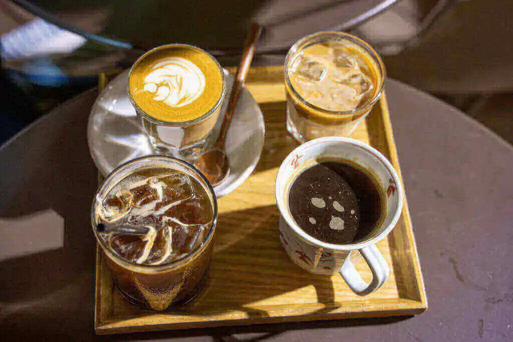 Four cups of coffee on wooden tray