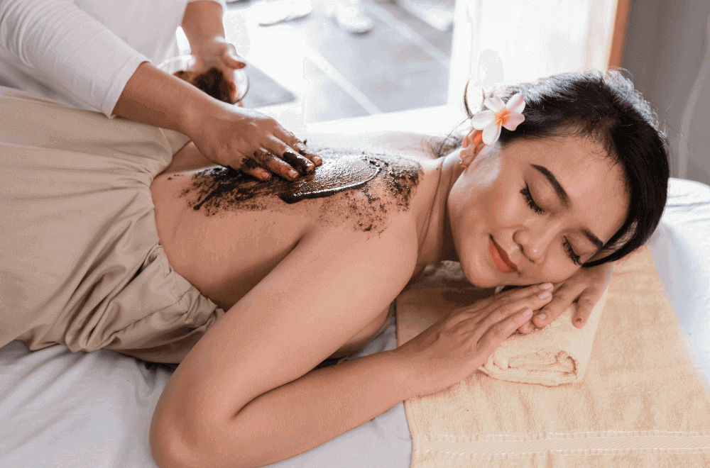 Woman enjoying a coffee scrub massage at the spa