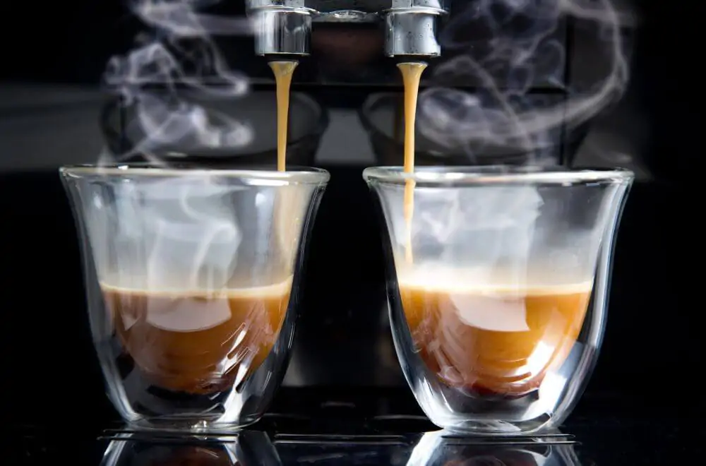 Golden espresso flows into the cups