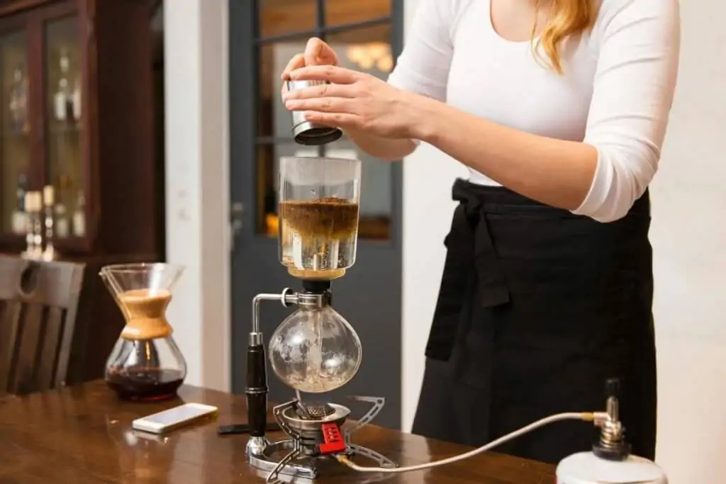 Woman barista making coffee using old fashion coffee dripper
