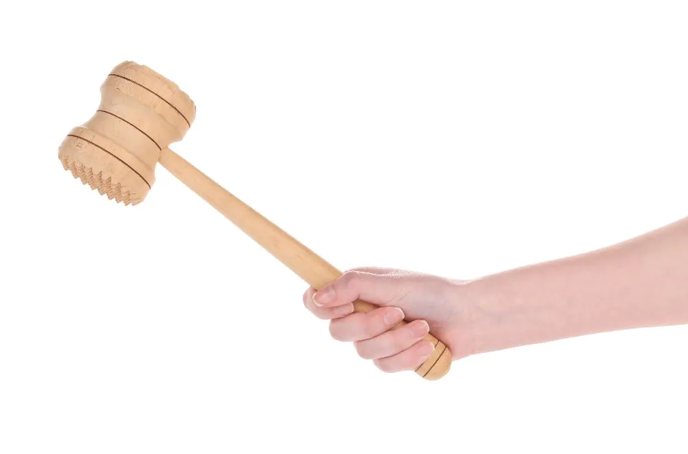 Hand holds wooden meat mallet