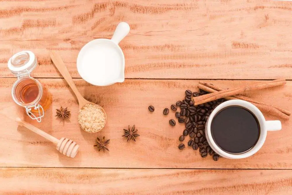 Cup of coffee with milk honey on wooden table