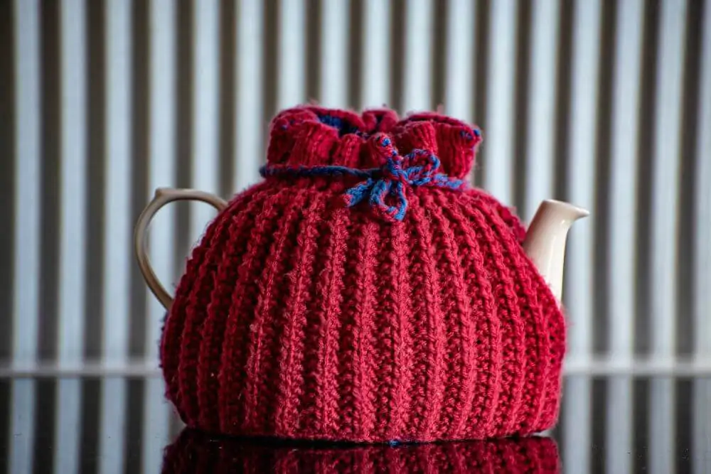 Teapot in red knitted cosy