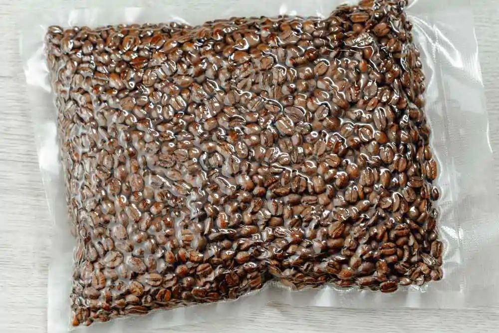 Fresh roasted coffee beans packed in vacuum sealed bag on wooden background