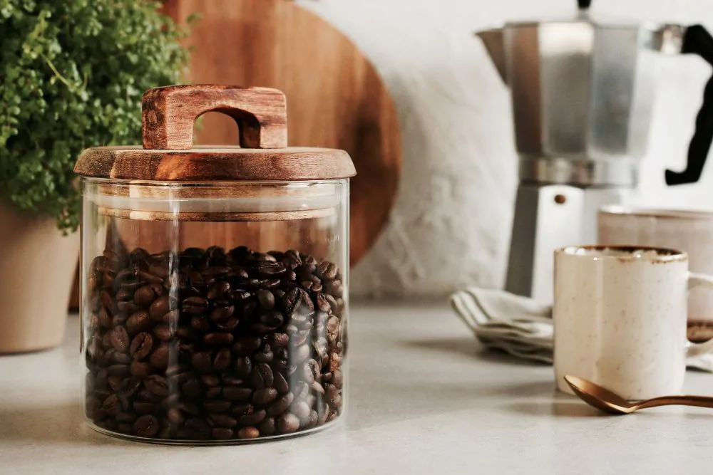 Glass jar with coffee beans, wooden kitchenware