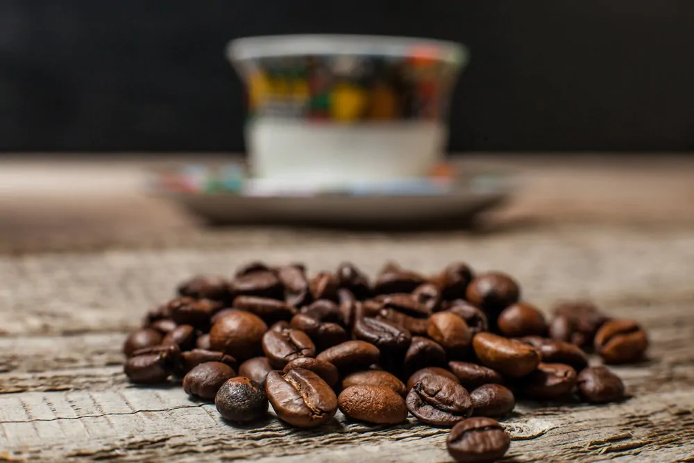 Coffee beans on front of picture and Ethiopian cup .Small depth of focus.