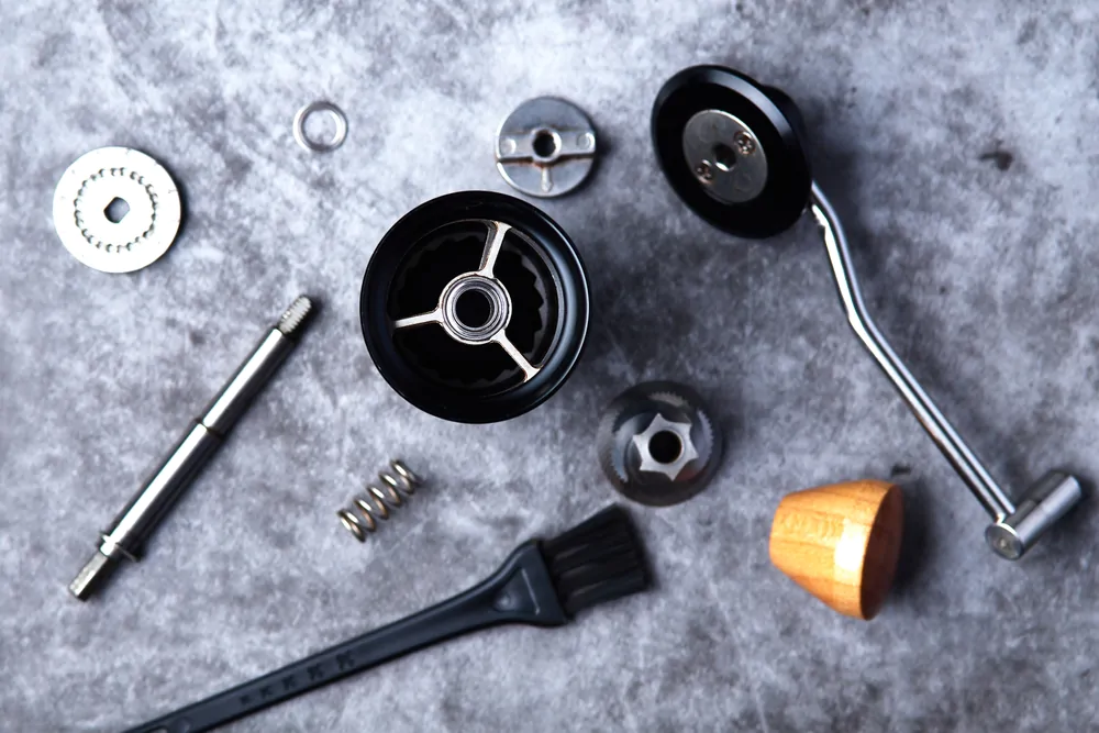 Top view of disassembled manual coffee grinder on grey background