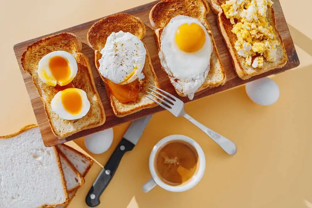 Fried Toast bread with four different types of cooked chicken eggs, scrambled eggs, fried eggs, poached egg and creamed egg. Breakfast of chicken eggs.